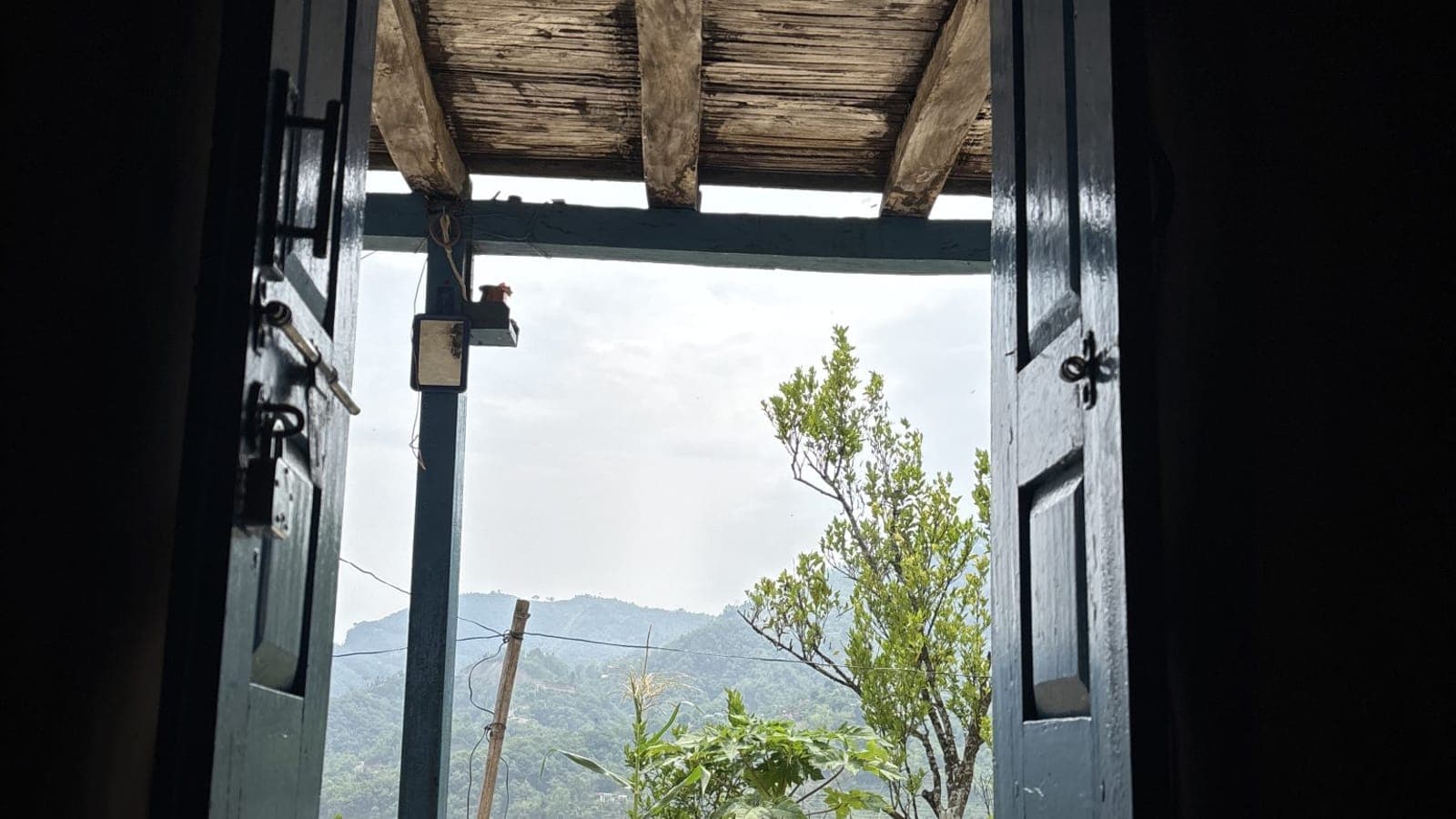 An open door revealing light and a green landscape