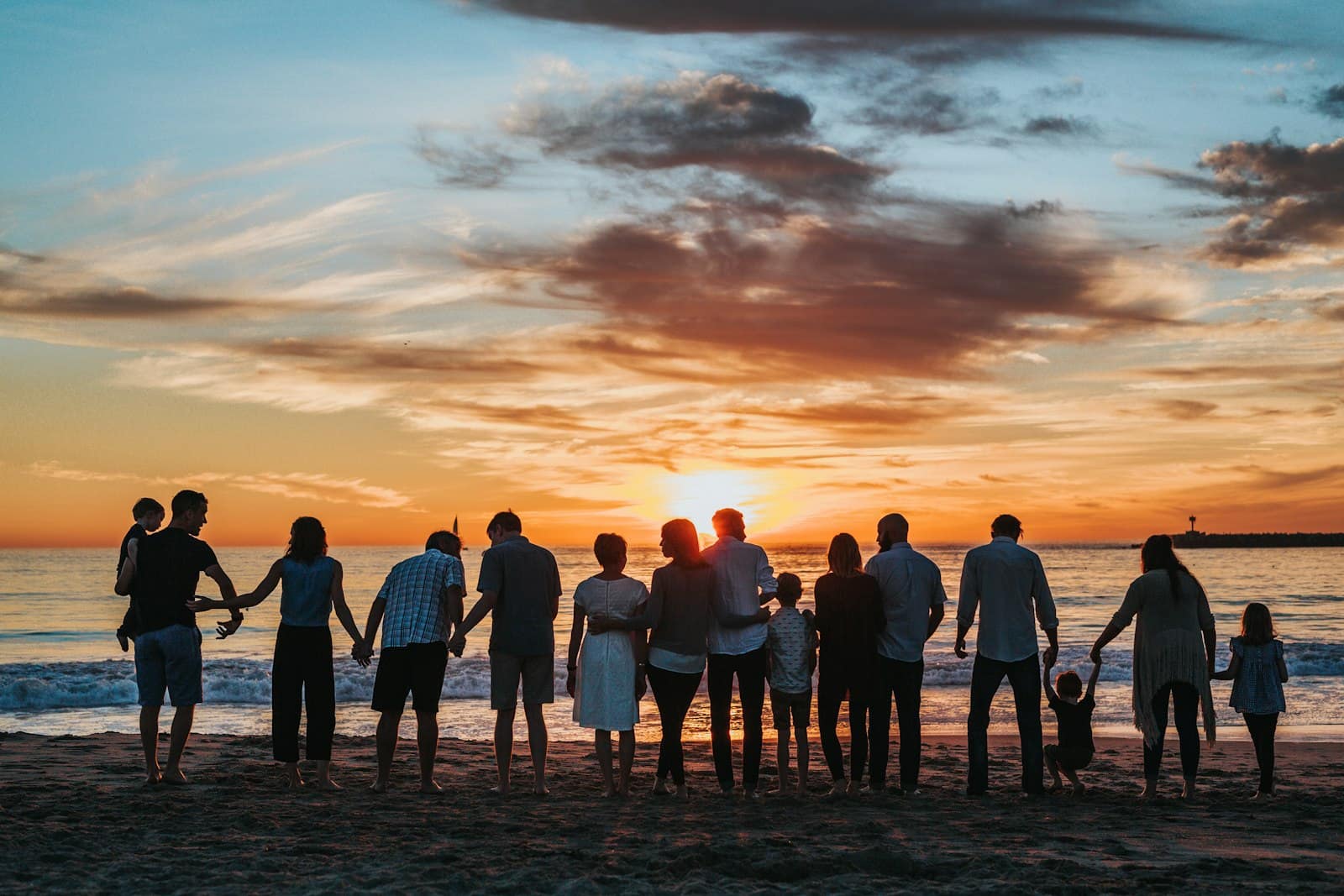 A family standing together on a beach at sunset
