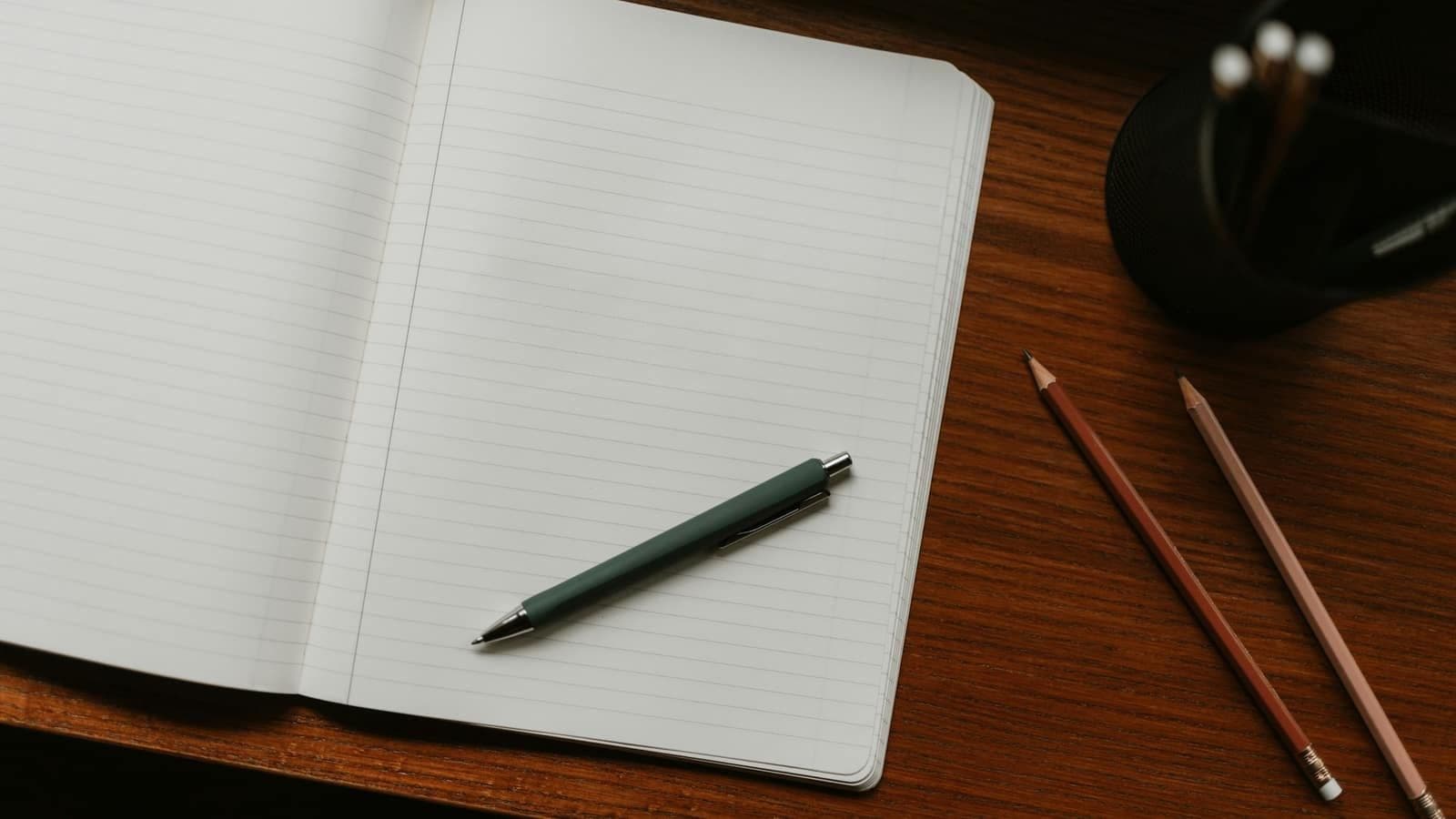 An open notebook with a pen on a desk