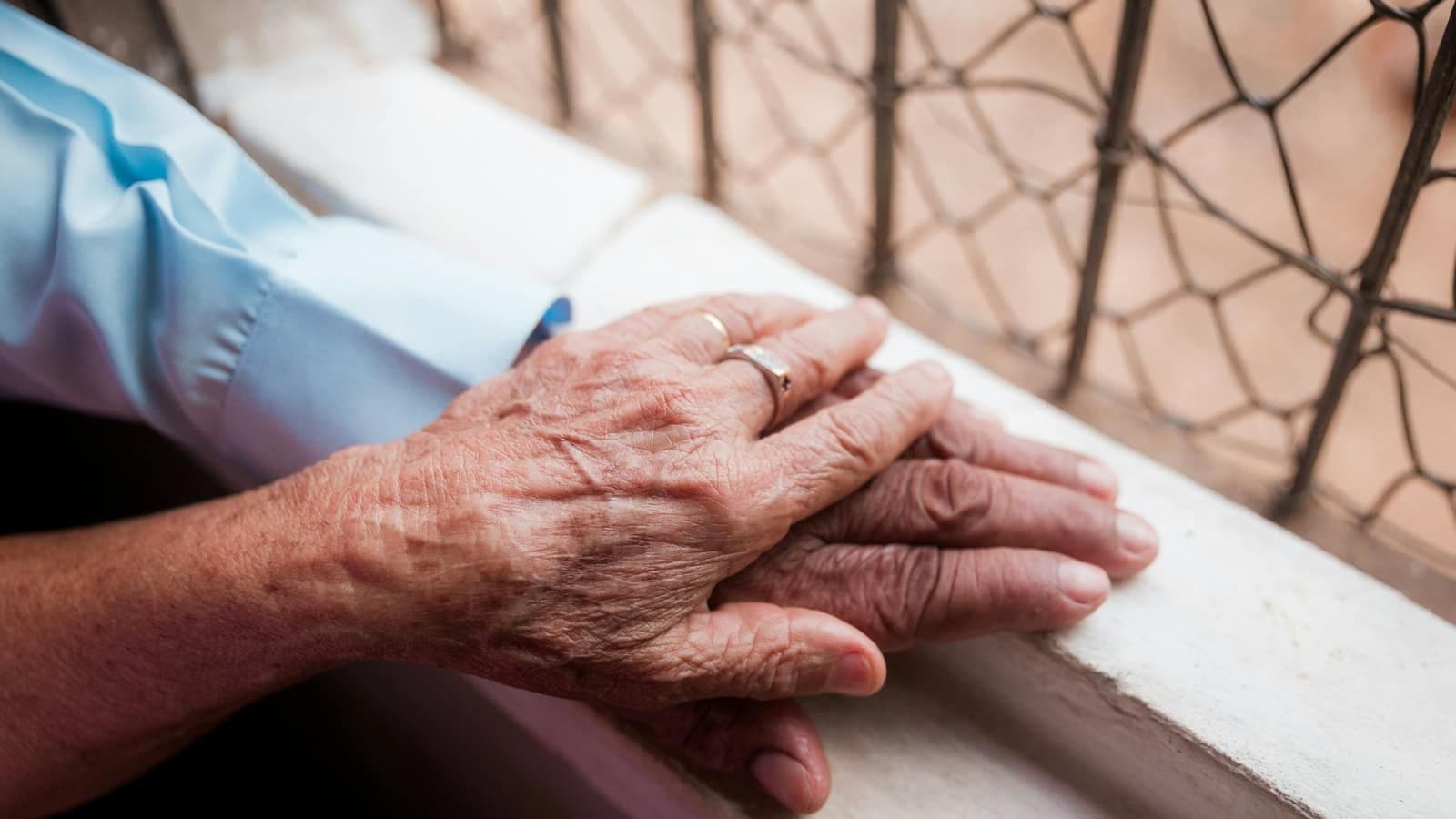 An older person's hand holding a younger person's hand