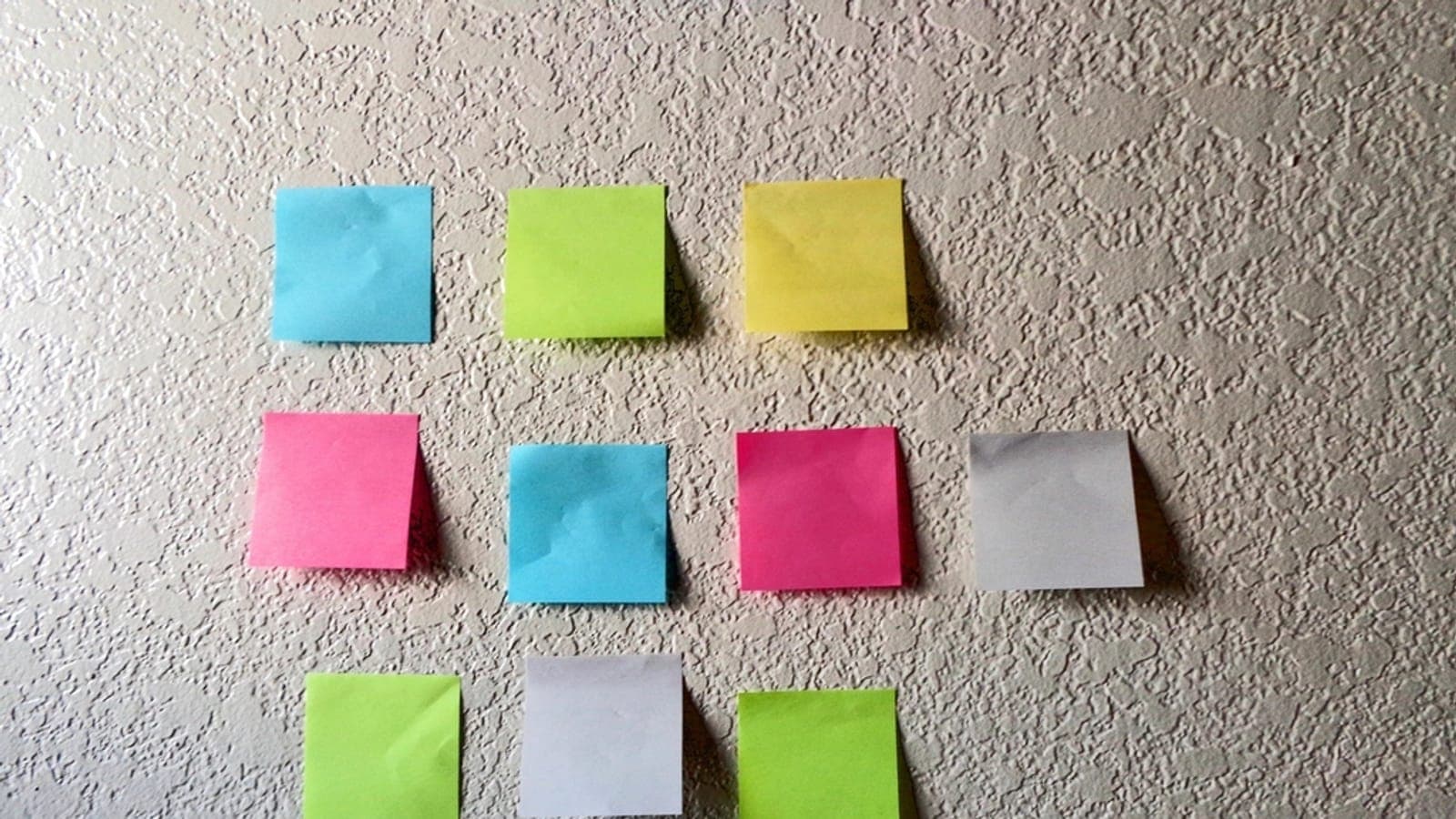 Blank coloured sticky notes on a wall